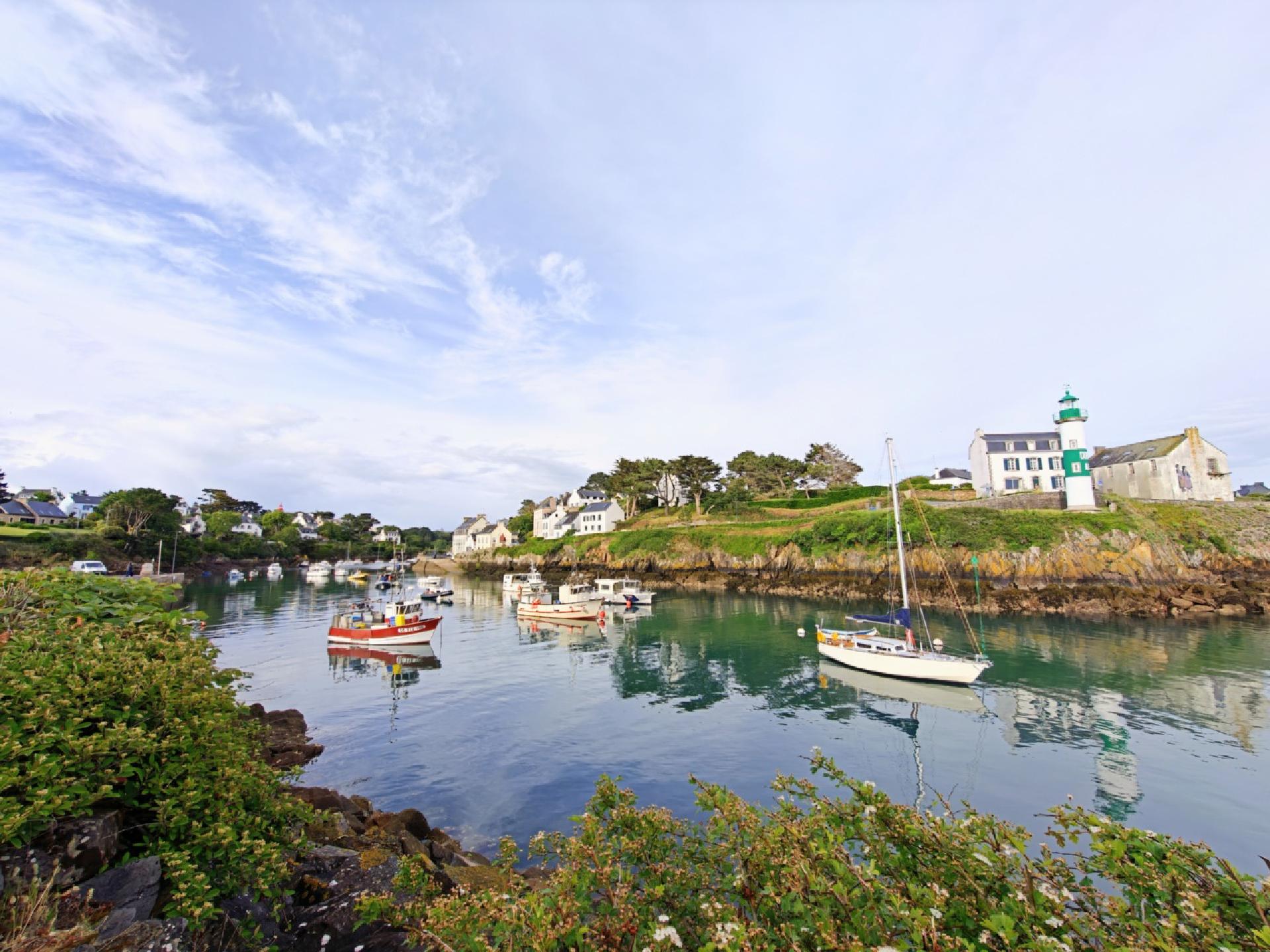 Vue panoramique du port avec un phare vert à droite.
