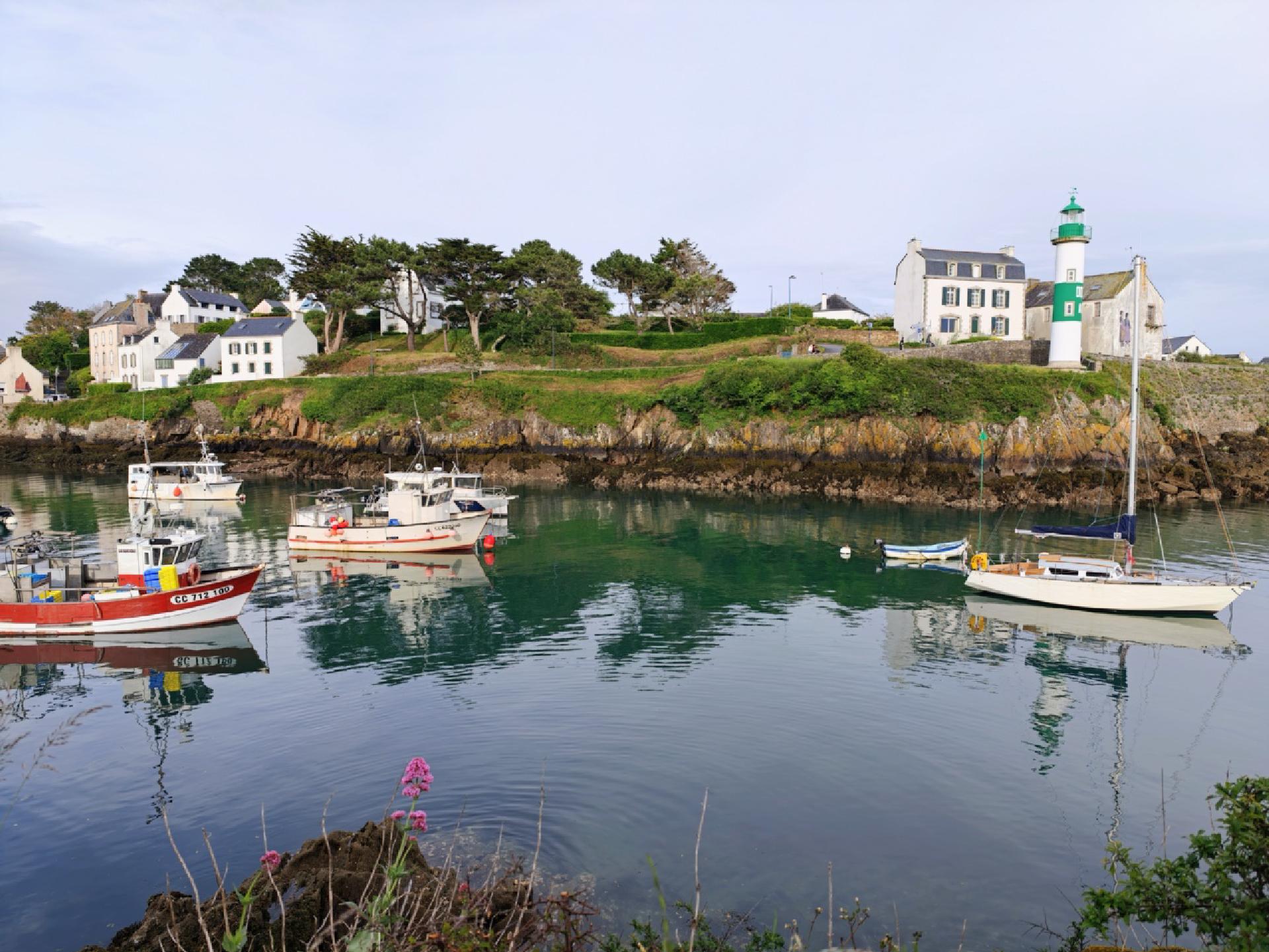 Vue du port avec des bateaux et des reflets sur l'eau.