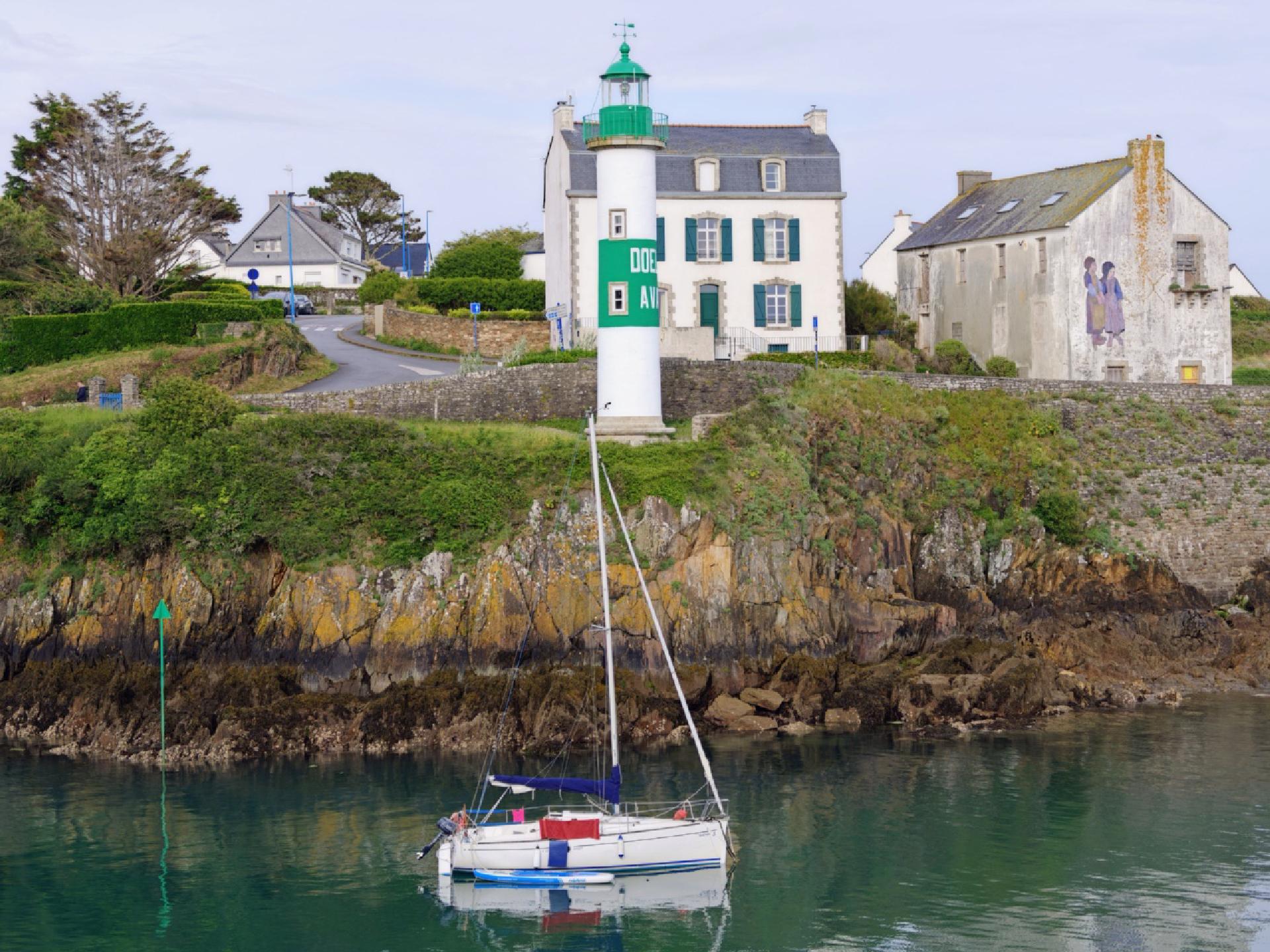 Un bateau à voile avec un phare vert au-dessus