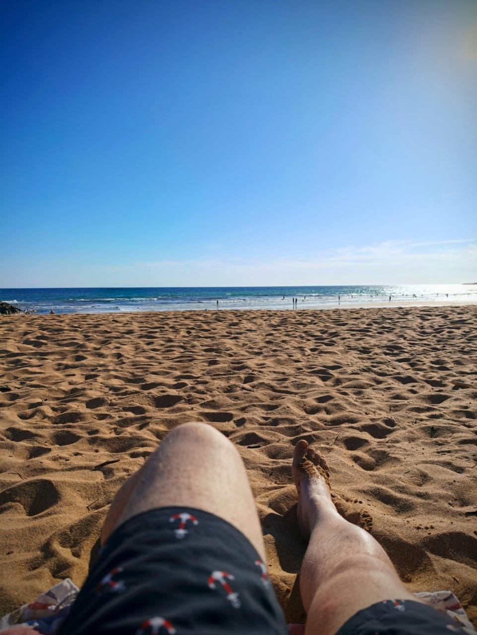 vue subjective de mes cuisses et la plage avec un ciel bleu immaculé
