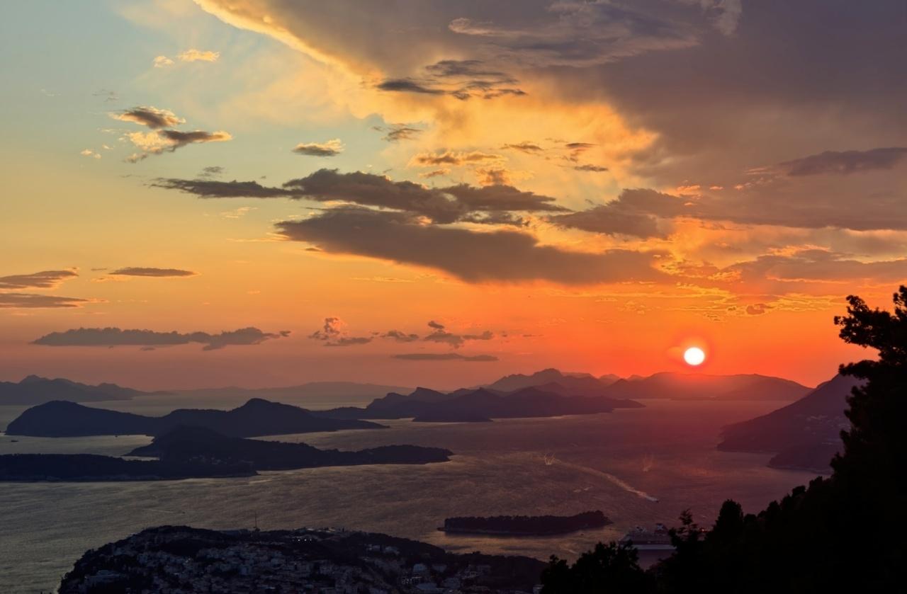 soleil presque couché sur des îles de l'Adriatique depuis le haut du mont Srđ