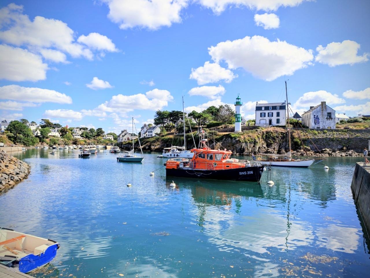 Un bateau de la SNSM dans le port avec le reflet du ciel sur l'eau